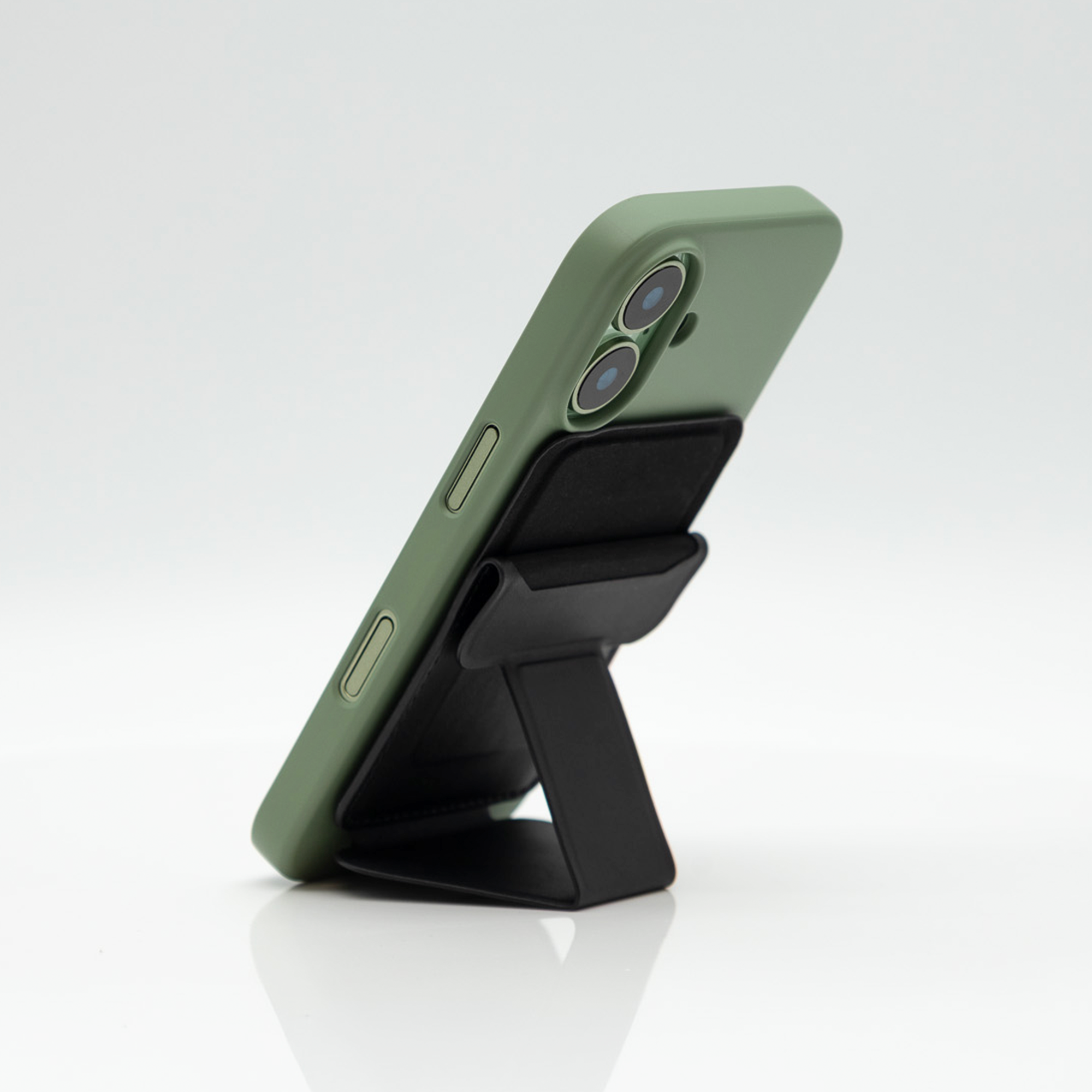 Black Peel Magnetic Wallet Stand propping a green-cased iPhone upright in portrait mode